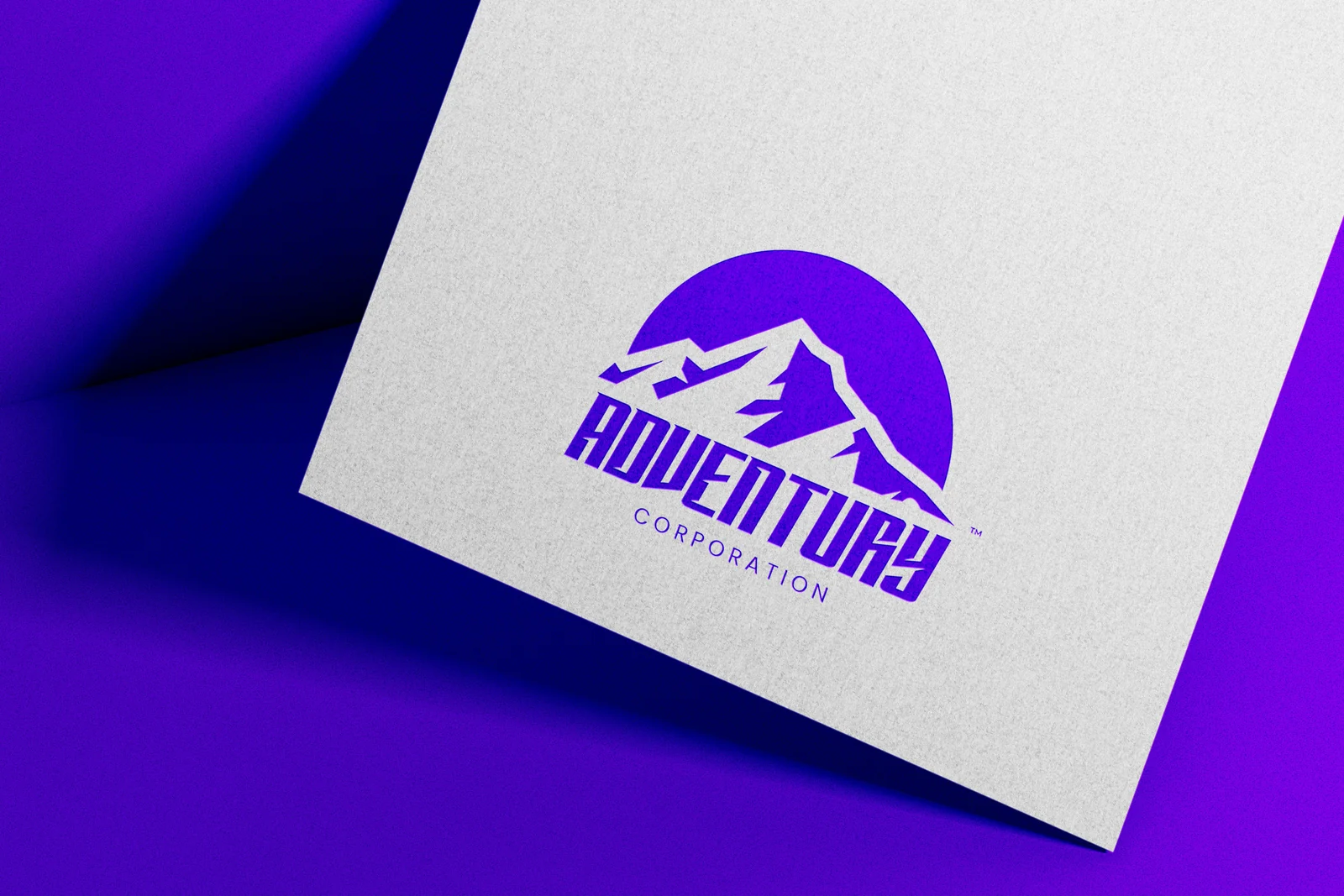 Identidade da Adventury Corporation: montanhas e sol roxos sobre papel